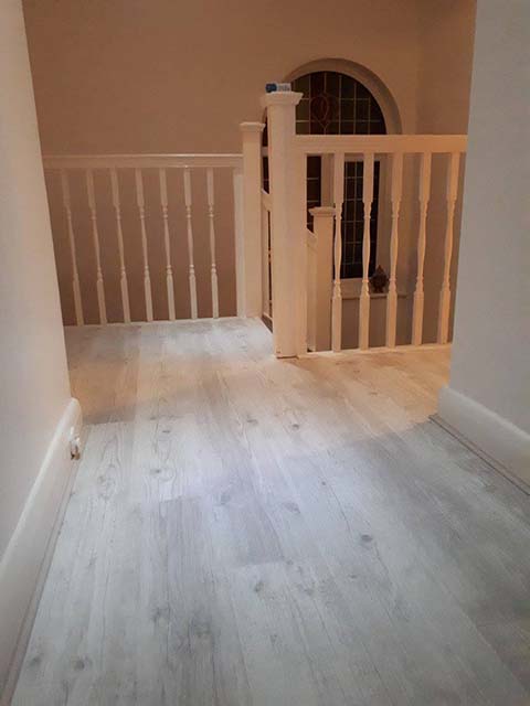white hardwood floor in landing of large home